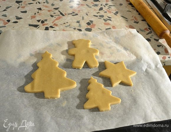 Достаем тесто частями и раскатываем на бумаге для выпечки. Толщиной  0,5-0,7 см. Вырезаем  тонким стаканом круглые прянички. Не трогать пряники руками. Просто удалить тесто между кружками.
Перевернем противень ,чтобы использовать не углубленную сторону, а обратную. Осторожно сдвигаем печенье на бумаге на противень.
