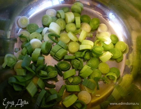 Лук-порей нарезаем крупными колечками. В кастрюлю с толстым дном наливаем оливковое масло и пассеруем лук до мягкости.
У меня был небольшой стебель порея. Я использую как белую, так и зеленую часть лука.