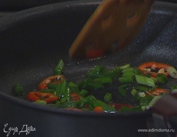 Разогреть в сковороде со съемной ручкой оливковое масло и прогреть лук и перец чили.