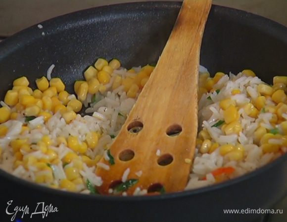 Добавить к луку с чили готовый рис, посолить, поперчить и обжарить, затем добавить кукурузу, все перемешать.