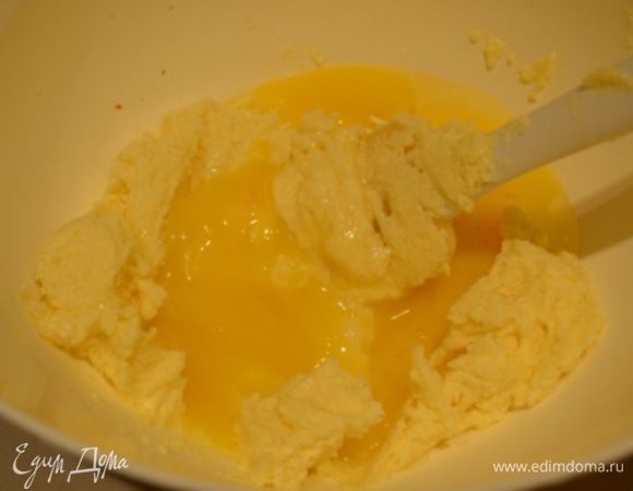 Мягкое сливочное масло взбить с сахаром в пышную белую массу. Добавить желтки по одному и перемешать лопаткой до однородности. 