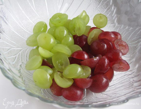 Темный и светлый виноград лучше взять без косточек.  Если виноград с косточками, то разрезать пополам и удалить косточки.  Выложить в салатник.