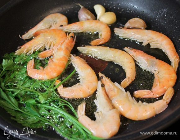 Добавляем петрушку (не резанную) и раздавленные зубчики чеснока. Готовим 2-3 минуты, пока чеснок не даст аромат.
После этого добавляем мытые креветки.