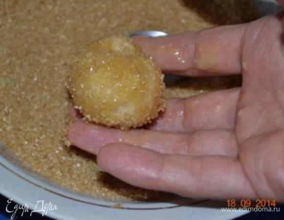 Работа с тестом. Отрывать от теста небольшое количество, сформировать шарик, размером чуть больше грецкого ореха - имейте ввиду, что он  еще увеличится в два раза в процессе приготовления.
На этом этапе вы можете положить в шарик теста кусочек яблочка, вишню,изюм, шоколад или орешек. У меня вяленая вишня. Окунуть его со всех сторон в сливочное масло, а затем обвалять в сахарно-коричной смеси. Уложить в подготовленную форму.