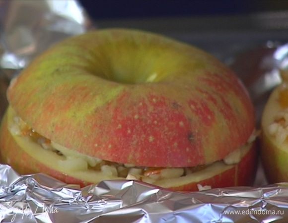 Небольшую форму для выпечки выстелить фольгой так, чтобы края сильно свешивались, уложить в нее чашечки яблок, наполнить их начинкой и накрыть «крышечками».