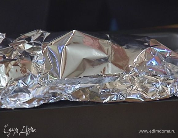 Закрыть яблоки свисающими краями фольги, скрепить ее и отправить форму в разогретую духовку.