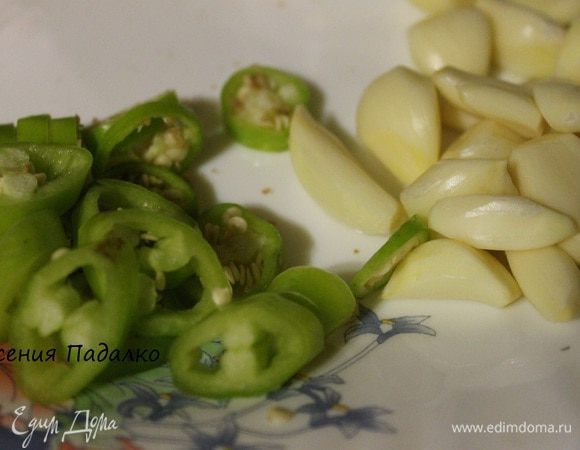 Очистить чеснок и нарезать его пластинками. Перец горьки помыть и нарезать кружочками.
