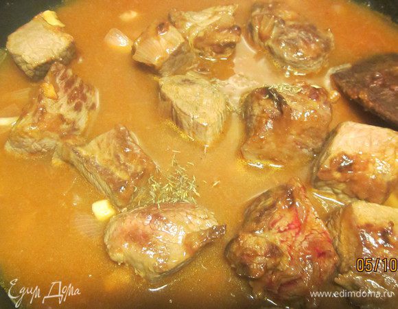 Добавляем воду так, чтобы она полностью покрыла мясо. Солим, перчим по вкусу, кладем веточку тимьяна (или хорошую щепотку сушеного). Накрываем крышкой и готовим на среднем огне 1 ч 15 минут, периодически помешивая. 
