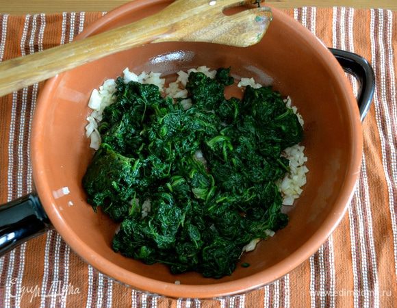 Зеленый лук нарезать помельче (можно использовать обыкновенный репчатый лук). В глубокой сковороде разогреть оливковое масло, положить нарезанный лук и обжарить пару минут (на зажаривая!). Добавить шпинат. Перемешать и обжарить все еще пару минут.