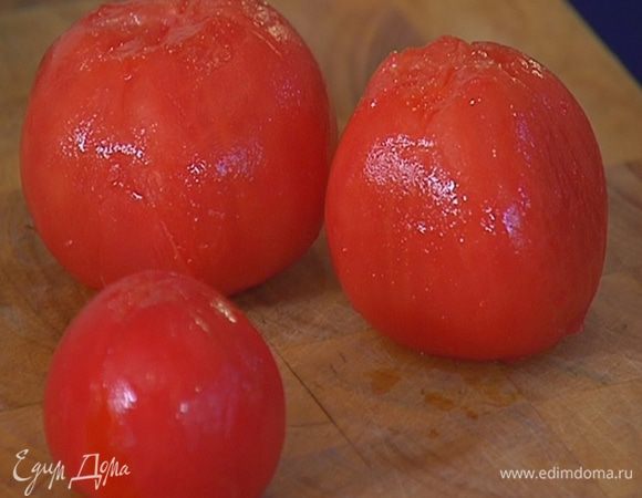 Помидоры надрезать крестиком, поместить в глубокую посуду и залить на некоторое время кипятком, затем промыть под холодной водой и снять кожицу.