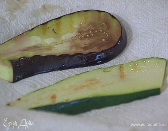 Разогреть в сковороде-гриль оливковое масло и обжарить баклажан и цукини до готовности, затем выложить на бумажное полотенце.
