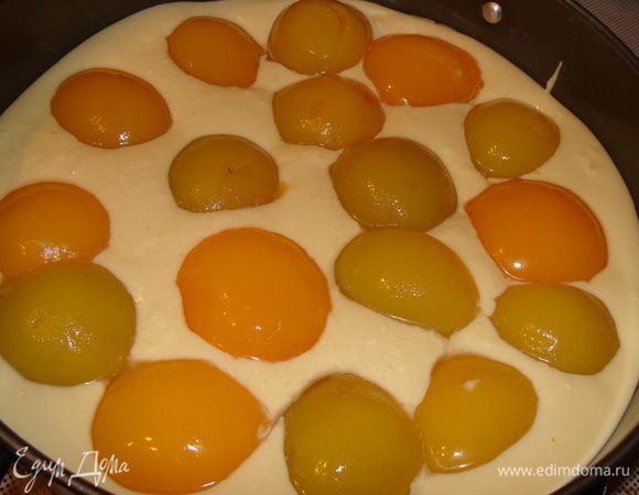 Добавляем яично-молочную смесь в масляную. Хорошенько взбиваем. Просеиваем муку с разрыхлителем и шафраном в нашу смесь. У меня был готовый разрыхлитель с шафраном. Все тщательно перемешиваем и выливаем в форму, застеленную пергаментом. Диаметр 24 см. Персики предварительно необходимо достать из банки и дать стечь лишней жидкости. Сверху теста выкладываем половинки персиков.