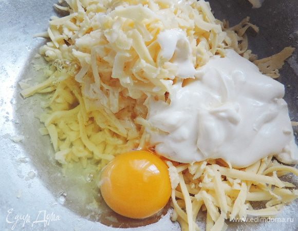 Тем временем приготовим начинку. Натрем на терку сыр, туда же добавим сметану, яйцо и белок от второго яйца. Желток нам пригодится для смазывания пирога. Все перемешиваем до однородности. Можно слегка посолить - все зависит от ваших вкусовых предпочтений и от того, насколько соленый у вас сыр.