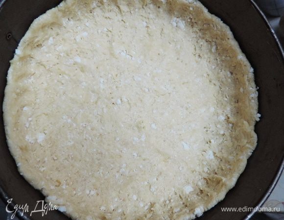 Делим тесто на 1/3 и 2/3 части. Большую часть руками распределяем по форме диаметром 23 см, смазанной растительным маслом и выстеленной бумагой для выпечки. Бортики делаем почти на всю высоту формы.