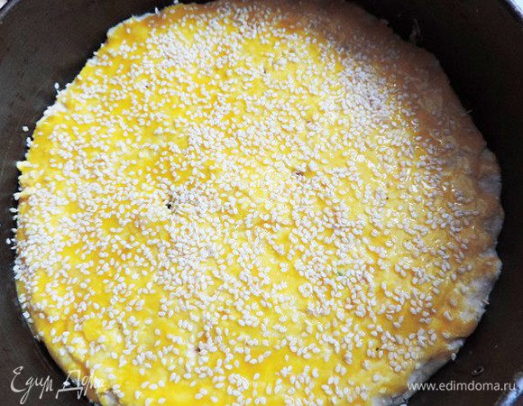 Смазываем верх пирога желтком и посыпаем кунжутом.