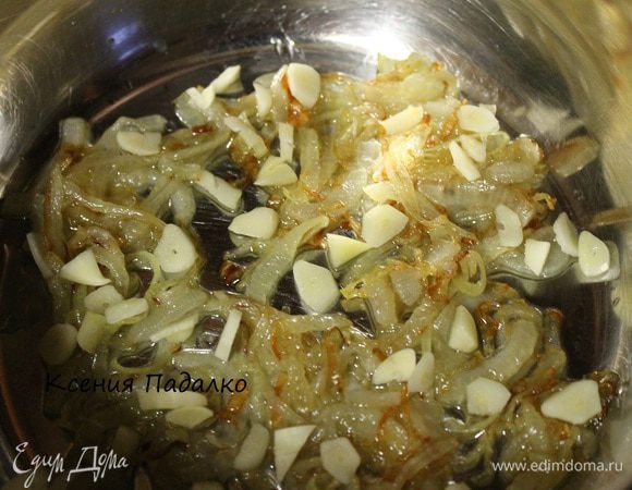 Лук почистить и нарезать полукольцами. Обжарить в 3-х ст.л. растительного масла. Обжаренный лук сложить в кастрюлю. 3 зубка чеснока нарезать пластинками и выложить поверх лука.