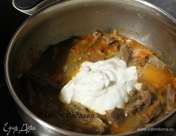 Пробуем мясо, если оно мягкое, добавляем сметану, также пробуем на соль. Перемешать все вместе, накрыть крышкой и протушить 5 минут.