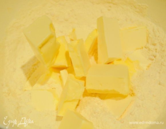 Холодное масло нарезать на кубики и добавить в сухую смесь, растереть все руками в крошку.