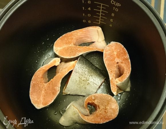 Смазываем маслом дно кастрюли мультиварки. Выкладываем ровненько кусочки рыбы.