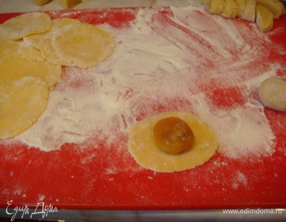 Тесто раскатать колбаской, нарезать на 44 части,раскатать и завернуть курагу,положить колобок в ладошку и слегка прижать,получаются ровные колобки.