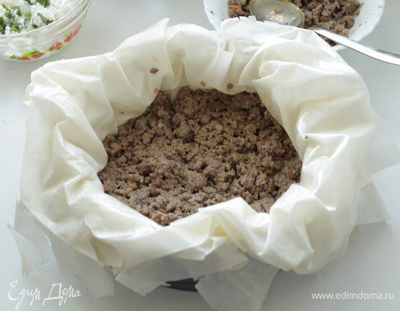 Берем разъемную форму, смазываем ее маслом. Выкладываем аккуратно друг на друга все шесть листов. Выкладываем половину фарша.