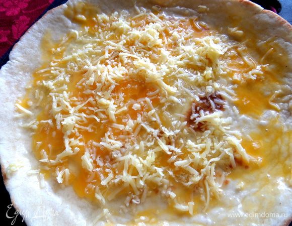 Стараемся белком попасть до краёв-это поможет склеить и удержать треугольник в нужной форме. Сверху посыпаем тёртым сыром. Если сыр не солёный,можно посолить и поперчить тоже!