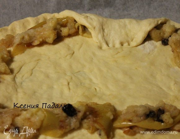 Отщипываем не большой кусочек теста, размером с апельсин и откладываем его в сторону. Остальное тесто раскатываем в виде овала. Запеченные яблоки размять вилкой и посыпать ,если нужно сахарной пудрой. Далее отступаем от края теста 2 см.  и формируем овал из яблок. И заворачиваем края теста внутрь.