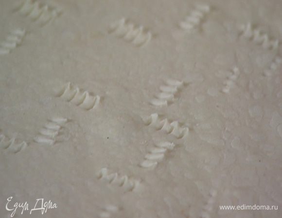 Рабочую поверхность посыпать мукой, раскатать тесто и часто наколоть его вилкой.