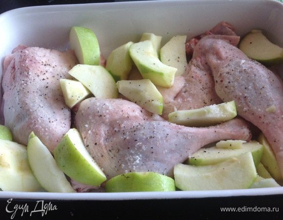 Утиные ножки вместе с яблоками выложите в форму для запекания и готовьте в духовке около часа.