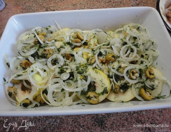 Яблоки вымыть и очистить и, аккуратно удалив сердцевину, нарезать кружками толщиной около 1 см. Нарезанные яблоки выложить в смазанную жиром форму. Сверху выложить лук с зеленью и маслинами.