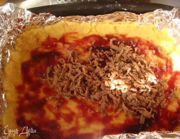 Светлое тесто руками распределить в форме(18х23 форма),промазать вареньем 2 ст.л..
Из морозильника достаем тесто шокол. и натереть 1.2 часть на светлое тесто.