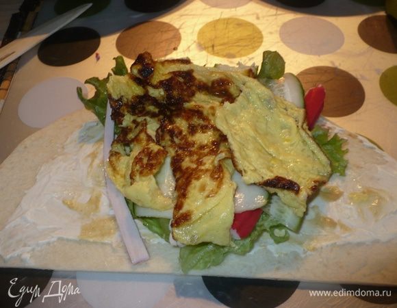 Сверху омлет и скрутить рулетик, закрепить зубочисткой.