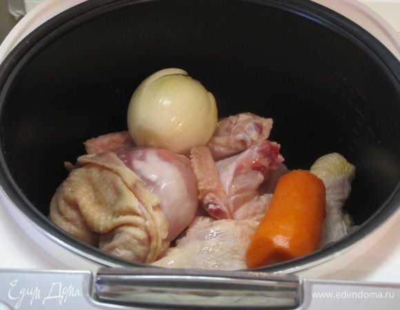 Курицу промыть, разрезать на 4 части, выложить в чашу мультиварки. Добавить очищенные морковь и репчатый лук.