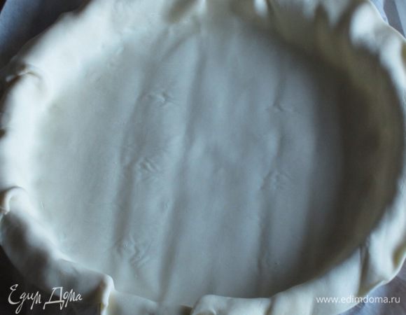 Слоёное тесто раскатать и выложить в форму диаметром 24 см с пергаментом.