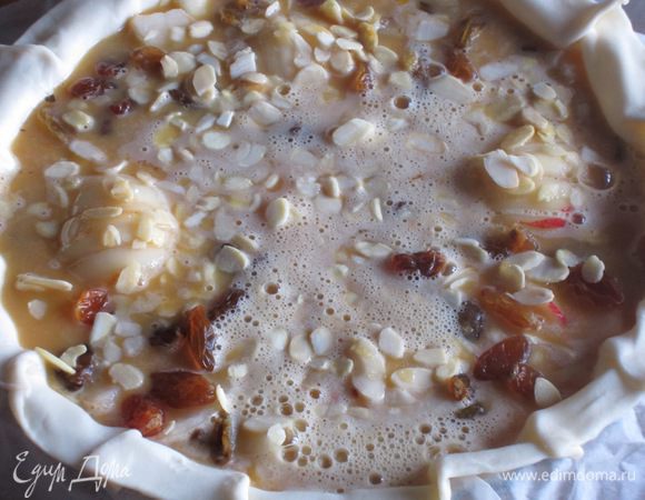 Сверху вылить заливку, посыпать оставшимися миндальными лепестками и выпекать в разогретой до 180°С духовке 30 минут.