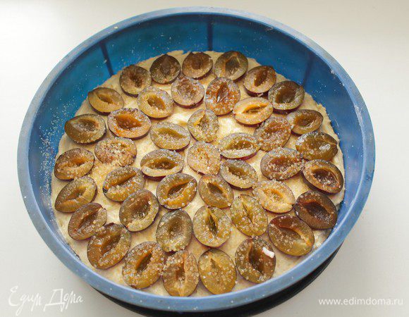 Выложить  тестао в форму (у меня d25 см, ), сверху выложить половинки слив.  и присыпать немного тростниковым сахаром.
