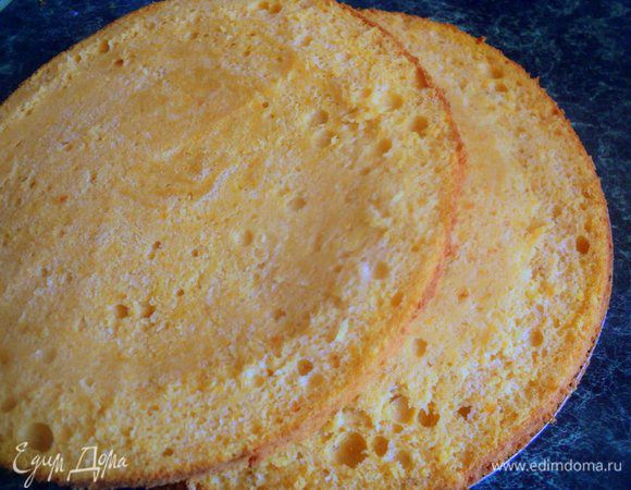 Бисквит охладить в форме на решетке, затем срезать тонким слоем верх коржа (понадобится для крошки для обсыпки боков торта) и разрезать на два пласта.