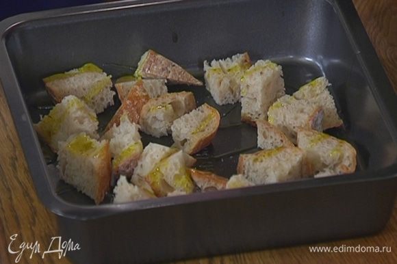 Хлеб нарезать небольшими кубиками, выложить в противень, сбрызнуть оливковым маслом и отправить в разогретую духовку на 10–15 минут.