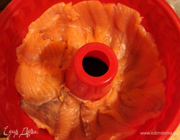 Слабосоленый, а лучше подкопченный лосось порезать тонкими пластами.
Выложить на дне формы, у меня она закрылась чуть больше, чем на половину.