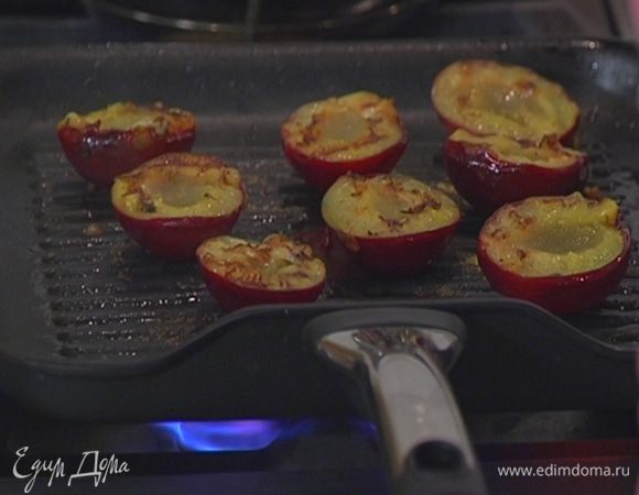 Из сковороды слить лишний жир, уложить в нее сливы срезами вниз и обжаривать до появления золотистых полосок.