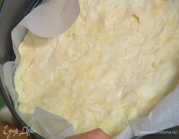 Разъемную форму выстелить бумагой для выпечки и равномерно распределить тесто, так чтобы получились небольшие бортики. Часто наколоть тесто вилкой и выпекать в разогретой духовке 15 минут.