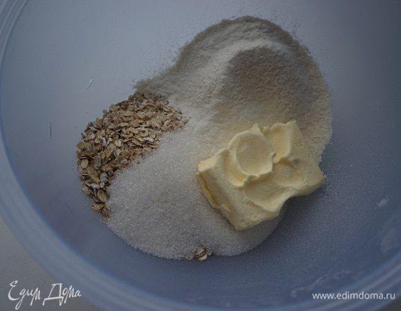 Включить разогреваться духовку до 180 градусов.

В миске смешать хлопья, муку, белый сахар и размягченное сливочное масло. Перетереть руками. Я использовала 0,5 стакана сахара – было чуть сладковато, так что в ингредиентах я убавила кол-во до 1/3 стакана. Но смотрите по Вашим предпочтениям.
