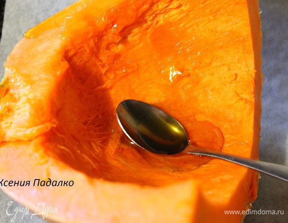 У меня была половинка тыквы, разрезать ее на две части. Противень застелить пергаментом. Положить кожурой вниз тыкву, мякоть смазать медом и поставить в заранее разогретую до 200 градусов духовку на 30-40 минут.