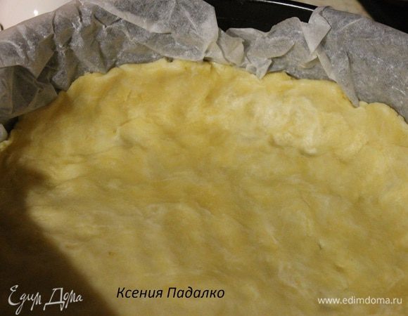 Разъемную форму 24 см, застилаем пергаментом и выкладываем в нее тесто. Разравниваем руками делая бортики 3-4 см.