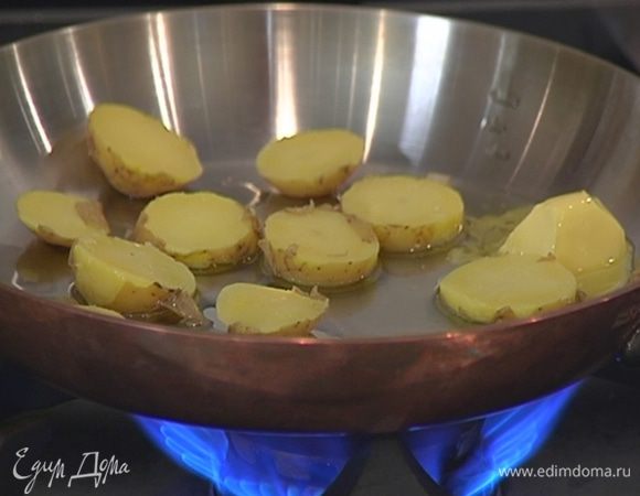 Разогреть в сковороде сливочное и оливковое масло и обжарить ломтики картофеля с двух сторон до золотистой корочки.