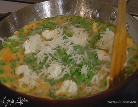 Посыпать омлет натертым козьим сыром и жарить еще пару минут до готовности.