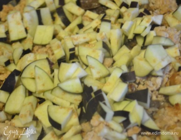 Добавляем мелко нарезанный баклажан, выдавливаем чеснок через пресс и жарим, пока баклажан не станет мягким. 