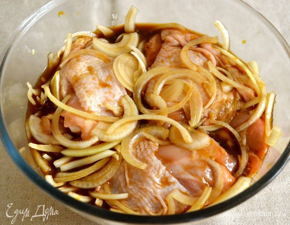 Куриные бедрышки вымыть, уложить в миску и залить полученным маринадом с луком, как следует перемешать и оставить мариноваться при комнатной температуре на 1 час. 