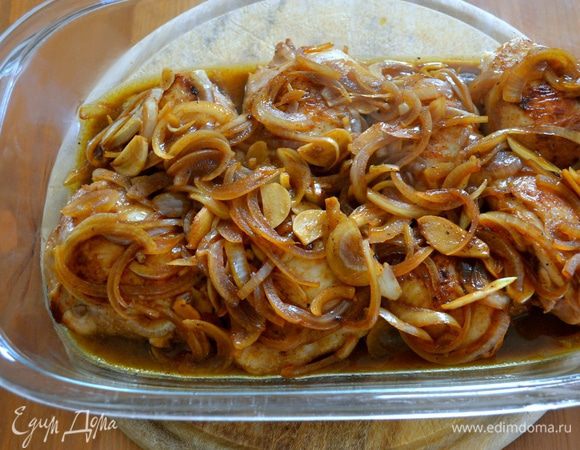 Залить куриные бедрышки маринадом и поставить в разогретую до 200°C духовку запекаться минут на 25-30. Если лук начнет подгорать, прикрыть блюдо фольгой...