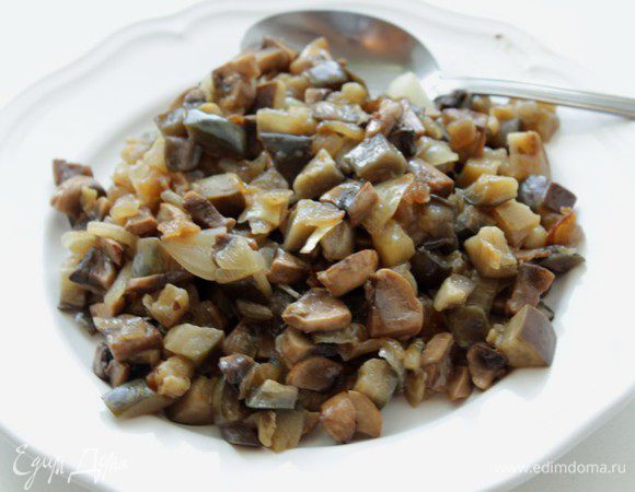 Мелко нарезать лук, обжарить на растительном масле. Затем кубиками нарезать баклажан, добавить к луку и следом шампиньоны. Все потушить мин 5, посолить, поперчить по вкусу.